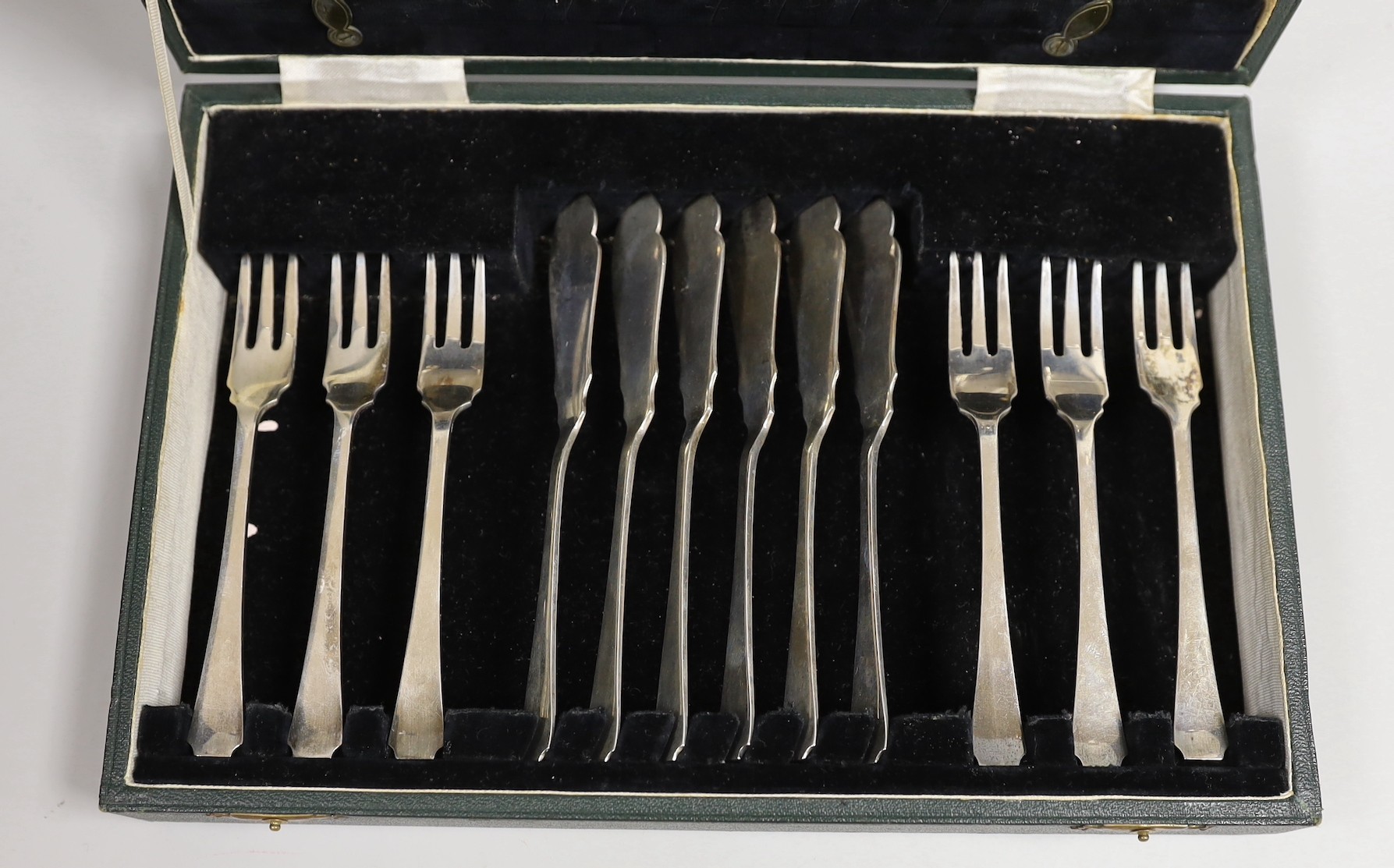 A cased set of six pairs of small silver fish eaters and three small pairs of servers, Thomas Bradbury & Sons, Sheffield, 1933